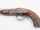 a close up of a gun with a wooden handle on a white surface