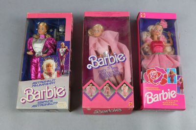 three barbie dolls are lined up in a row on a table