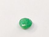 a close up of a green jade stone on a white surface