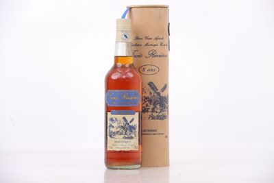 Des bouteilles d'alcool sont posées sur une table à côté d'un carton.