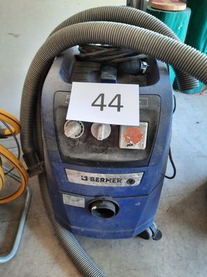 a blue vacuum that is sitting on the floor next to a hose
