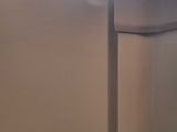 a cat sitting on top of a refrigerator in a kitchen