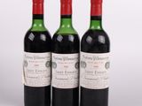 trois bouteilles de vin rouge posées l'une à côté de l'autre sur une surface blanche