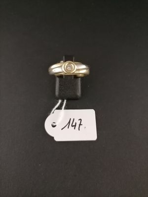 a close up of a gold ring on a black surface with a price tag