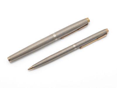 deux stylos posés l'un sur l'autre sur une surface blanche