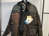 une veste en cuir suspendue à un portant, avec une étiquette accrochée dessus