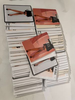 a pile of magazines on a table with a woman ' s legs on them