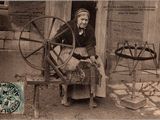 une vieille photo d'une femme en train de filer à l'aide d'un rouet