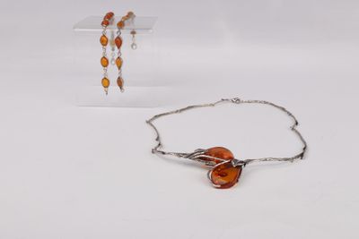 two pieces of jewelry sitting on top of a table next to each other
