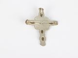 a close up of a silver cross on a white surface