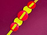 a yellow and red bracelet on a purple surface