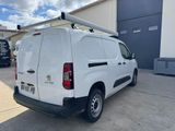 a white van parked in front of a building with a surfboard on the roof
