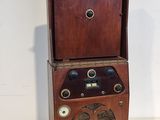 Une radio à l'ancienne est posée sur un meuble en bois