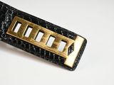 black leather belt with gold metal buckle on white surface