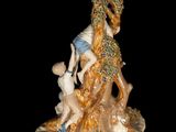 a figurine of a woman and two children sitting on a tree