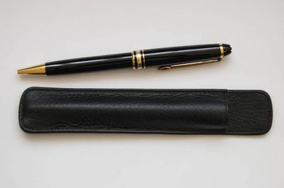 une image représentant un stylo et un étui à stylos posés sur une table