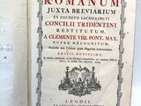 un vieux livre sur lequel figure l'image d'une ville romaine