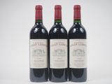 three bottles of red wine sitting next to each other on a white surface