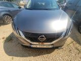 the front of a silver car parked in a lot with other cars