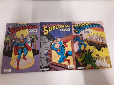 deux bandes dessinées de Superman posées sur une surface blanche