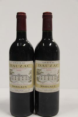 two bottles of red wine sitting next to each other on a white surface