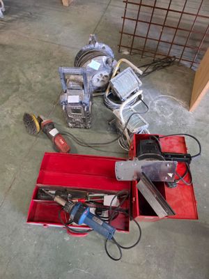 une boîte rouge contenant des outils, posée sur le sol