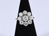 an antique diamond cluster ring on a black velvet ring stand