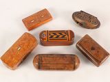several small wooden objects are arranged in a circle on a white surface