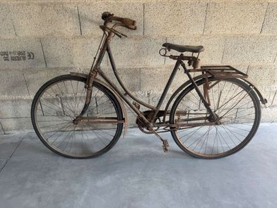 a old bicycle that is leaning against a wall