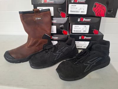 three pairs of black and brown work boots sitting on top of boxes