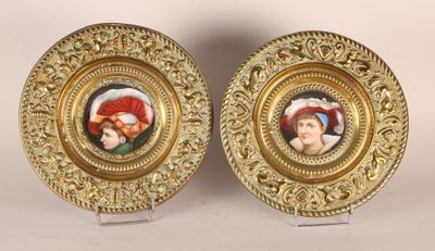 two gold plate with a picture of a man and a woman on them
