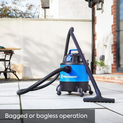 un aspirateur à sac sur une terrasse, avec une table et des chaises en arrière-plan