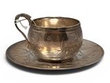 a silver cup and saucer on a saucer on a white background