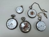 plusieurs types de montres de poche sont présentés sur une surface blanche