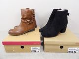two pairs of women ' s boots sitting on top of boxes