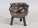 une vieille casserole en métal posée sur un support en bois