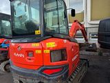 a picture of a small excavator parked in front of a building