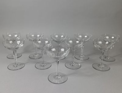 six clear wine glasses are lined up on a white surface