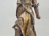 bronze statue of a woman holding a bird on a wooden base