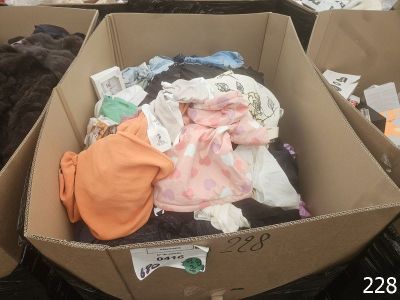 une boîte pleine de vêtements posée sur le sol