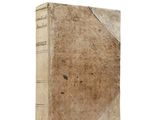 an old book sitting on top of a white table next to a white wall