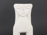 a white ceramic sculpture of a woman ' s face on a black background