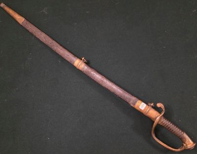 une vieille épée à la poignée en bois posée sur une surface noire