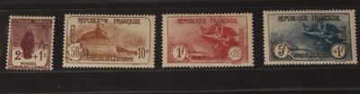 quatre timbres-poste de couleurs différentes sur un fond noir