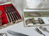 a box with silverware on a table with a knife, fork, spoon, and spoon rest