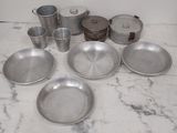 a lot of silver dishes and pans sitting on a counter