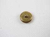 a close up of a gold button on a white surface