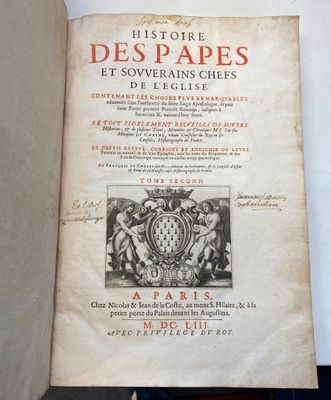 un livre ouvert sur lequel figure l'image d'un blason et un blason