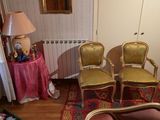 trois fauteuils dans un salon avec une table et une lampe