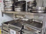 many pans on a metal shelf in a kitchen
